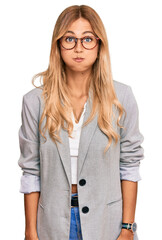 Beautiful blonde young woman wearing business clothes puffing cheeks with funny face. mouth inflated with air, crazy expression.