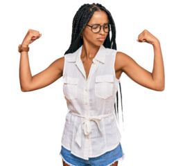 Beautiful hispanic woman wearing casual clothes and glasses showing arms muscles smiling proud. fitness concept.
