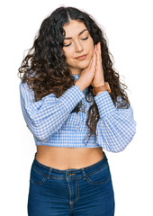 Young hispanic girl wearing casual clothes sleeping tired dreaming and posing with hands together while smiling with closed eyes.