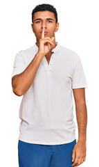 Young arab man wearing casual clothes asking to be quiet with finger on lips. silence and secret concept.
