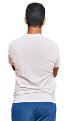 Young arab man wearing casual clothes standing backwards looking away with crossed arms
