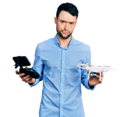 Hispanic man with beard using drone with remote control skeptic and nervous, frowning upset because of problem. negative person.