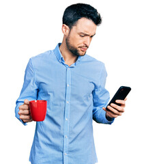 Hispanic man with beard using smartphone and drinking a cup of coffee skeptic and nervous, frowning...