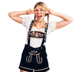 Young beautiful blonde woman wearing oktoberfest dress doing peace symbol with fingers over face, smiling cheerful showing victory