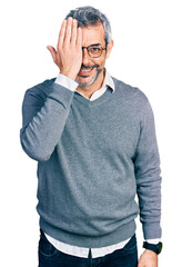 Middle age hispanic with grey hair wearing glasses covering one eye with hand, confident smile on face and surprise emotion.