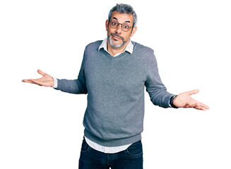 Middle age hispanic with grey hair wearing glasses clueless and confused expression with arms and hands raised. doubt concept. - obrazy, fototapety, plakaty