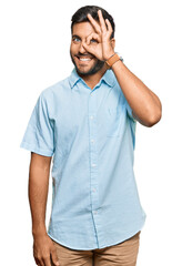 Fototapeta premium Handsome hispanic man wearing casual clothes doing ok gesture with hand smiling, eye looking through fingers with happy face.