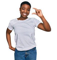 Young african american woman wearing casual white t shirt smiling and confident gesturing with hand...