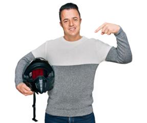 Handsome young man holding motorcycle helmet pointing finger to one self smiling happy and proud