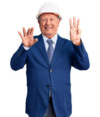 Senior handsome grey-haired man wearing suit and architect hardhat showing and pointing up with fingers number eight while smiling confident and happy.