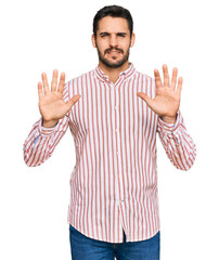 Young hispanic man wearing business shirt afraid and terrified with fear expression stop gesture with hands, shouting in shock. panic concept.