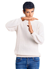 Young african amercian man wearing casual clothes doing time out gesture with hands, frustrated and...
