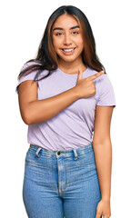 Obraz premium Young latin woman wearing casual clothes cheerful with a smile of face pointing with hand and finger up to the side with happy and natural expression on face