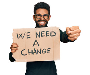 Young african american man holding we need a change banner annoyed and frustrated shouting with anger, yelling crazy with anger and hand raised