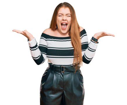 Young beautiful redhead woman wearing elegant clothes celebrating mad and crazy for success with arms raised and closed eyes screaming excited. winner concept