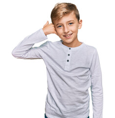 Little caucasian boy kid wearing casual clothes smiling doing phone gesture with hand and fingers like talking on the telephone. communicating concepts.