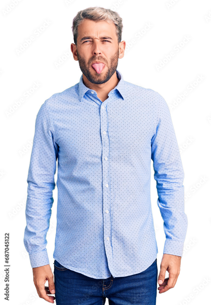 Sticker Young handsome blond man wearing elegant shirt sticking tongue out happy with funny expression. emotion concept.