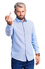 Young handsome blond man wearing elegant shirt showing middle finger, impolite and rude fuck off...