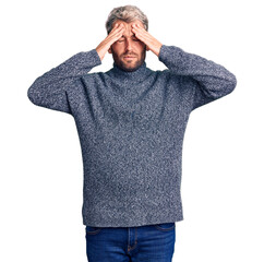 Young handsome blond man wearing casual sweater suffering from headache desperate and stressed because pain and migraine. hands on head.