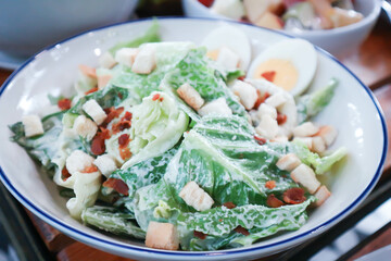 caesar salad or vegetable salad with bacon , egg and Bread Croutons