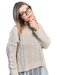 Young blonde woman wearing glasses thinking worried about a question, concerned and nervous with hand on chin