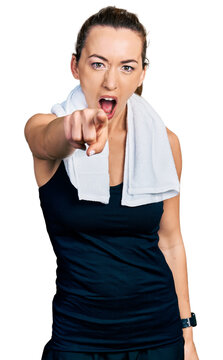 Young caucasian woman wearing sportswear and towel pointing displeased and frustrated to the camera, angry and furious with you