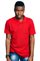 Fototapeta premium Young african american man wearing casual red t shirt depressed and worry for distress, crying angry and afraid. sad expression.
