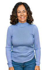 Middle age hispanic woman wearing casual clothes looking positive and happy standing and smiling...