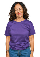 Middle age hispanic woman wearing casual clothes winking looking at the camera with sexy expression, cheerful and happy face.