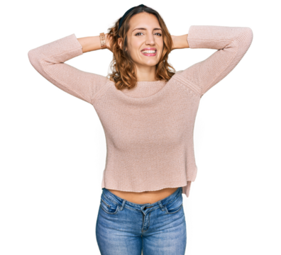 Beautiful young caucasian woman wearing casual sweater relaxing and stretching, arms and hands behind head and neck smiling happy