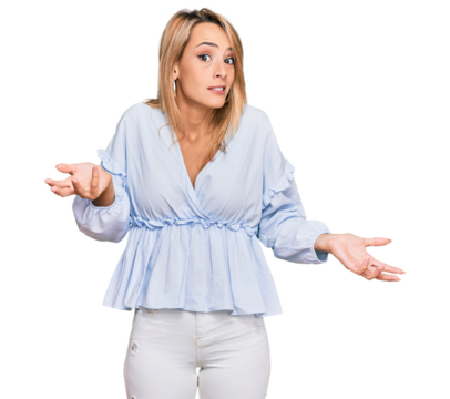 Beautiful blonde business woman wearing casual clothes clueless and confused expression with arms and hands raised. doubt concept.