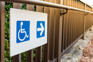 Disability access way sign for wheelchair users with right directional arrow sign for wheelchairs.