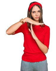 Young brunette woman wearing casual clothes doing time out gesture with hands, frustrated and...