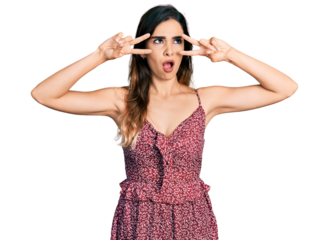 Beautiful hispanic woman wearing bohemian and hippie style doing peace symbol angry and mad screaming frustrated and furious, shouting with anger. rage and aggressive concept.