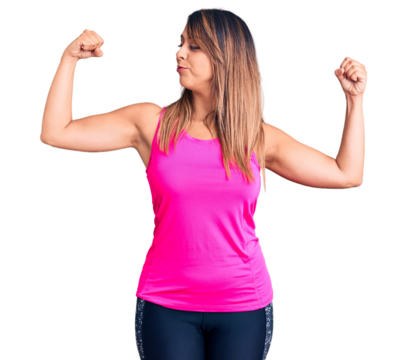 Young beautiful woman wearing sportswear showing arms muscles smiling proud. fitness concept.