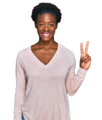 Young african american girl wearing casual clothes showing and pointing up with fingers number two while smiling confident and happy.