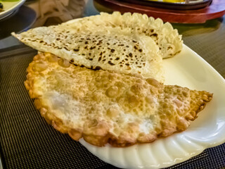 Traditional Uzbek chebureks (meat in dough) are on a plate in a restaurant