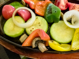 Fried vegetables: zucchini, peppers, onions, mushrooms are on a plate
