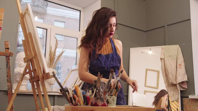 Yong Woman Painter Creating Artwork on a Studio Easel