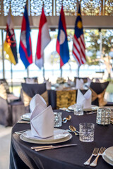 Official dinner set up with different country flags on background during government meeting, conference summit, forum or other international event - 687054385
