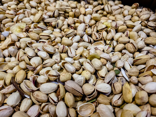 a lot of nuts: almonds, peanuts, pistachios are in a box in the store.