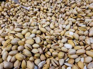 a lot of nuts: almonds, peanuts, pistachios are in a box in the store.