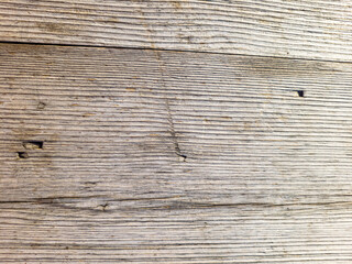 Fototapeta premium The wall of old boards natural wood. Weathered planks with a diagonal pattern. The tree darkened under the sun.