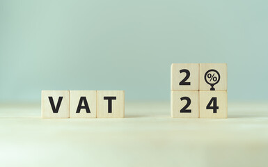 VAT in 2024 concept. Value Added Tax. VAT text and 2024 on wooden cubes with grey background.