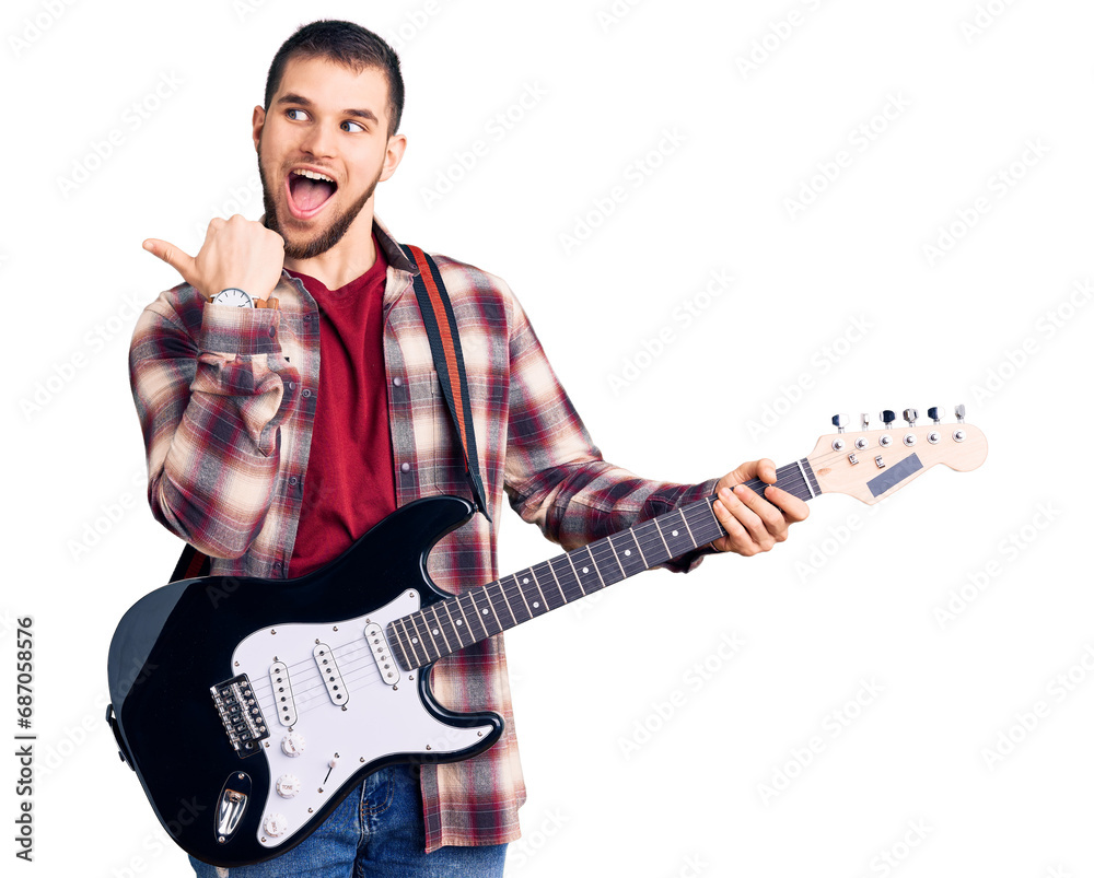 Sticker Young handsome man playing electric guitar pointing thumb up to the side smiling happy with open mouth