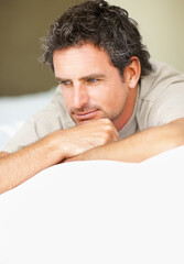 Thinking, relax and mature man in bed in the morning after nap, break or comfortable sleep at home. Smile, idea and male person from Canada wake up in bedroom for rest on cozy day in apartment.