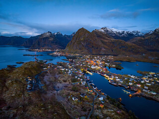 aerial view over early morning fisherman Sørvågen village bay with switched on street lights with...