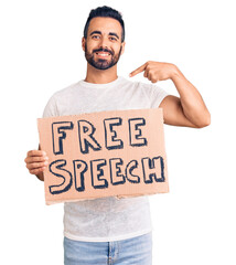 Young hispanic man holding free speech banner pointing finger to one self smiling happy and proud