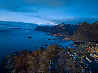 Fototapeta na wymiar aerial view of lofoten islands coast with villages on the shore with red houses during sunrise