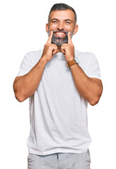 Middle age handsome man wearing casual white tshirt smiling with open mouth, fingers pointing and forcing cheerful smile